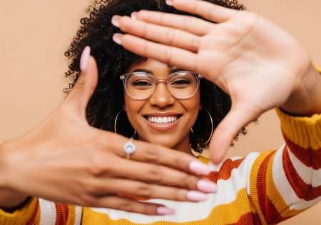 Cheerful african american woman in eyeglasses gesturing with handsの素材