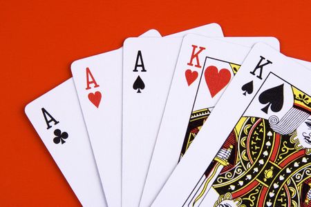 A full house poker game on red background.のeditorial素材