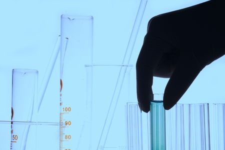 A hand holding a test tube in plain background.