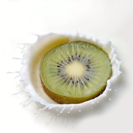 Fresh kiwi falling into the milk with a splash closeupの写真素材