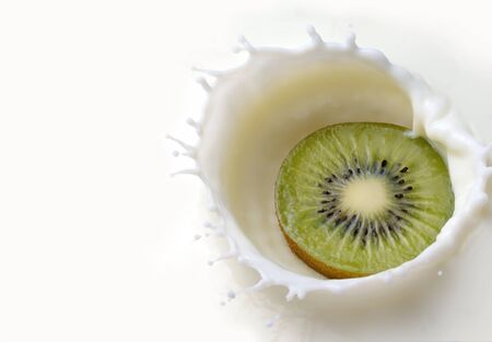 Fresh kiwi falling into the milk with a splash closeupの写真素材