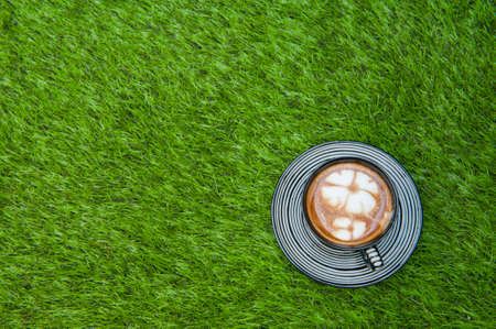 Coffee put on grass fieldの写真素材