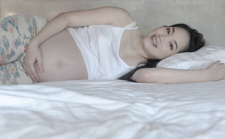 A pretty young pregnant asian womanの写真素材