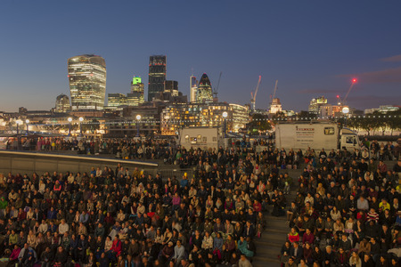 LONDON, UNITED KINGDOM - September 25: Large group of people are watching outdoor movie, the location near tower bridge on September 25, 2014 in Londonのeditorial素材
