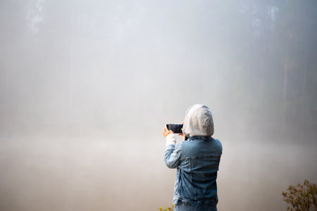 Happy traveler woman taking photo Nature view by smartphone, Thailand