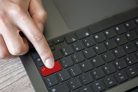 A keypad of laptop with finger hit on enter button