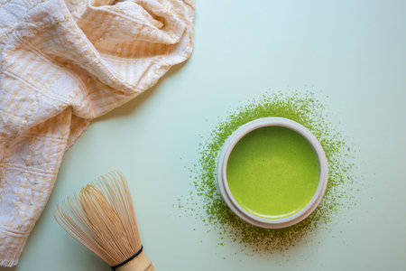 Matcha green tea on a pastel green background, shot in still life style.