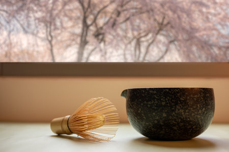 Matcha green tea brewing bowl on a warm background in a cherry blossom atmosphere, shot in a still...