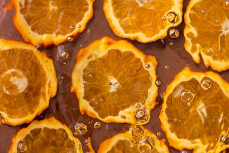 Photograph of bubbles on the surface of water with a halved orange in the background.の写真素材