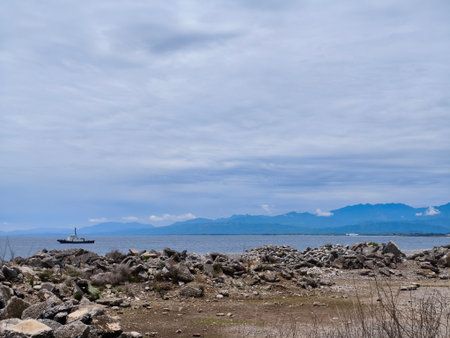 Boat on the seashore with mountains in the background.の写真素材