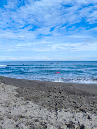 Black sand beach and red kayak on the sea in the morningの写真素材