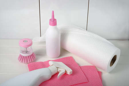 Cleaning and disinfection products pink cleaning brush and wipes on white background.