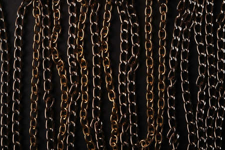 Background of gold and bronze chains on black paper