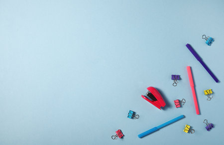 stationery felt-tip pens pins stapler on blue background. Flatlay.の写真素材