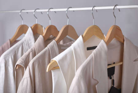 clothes in light pastel colors hanging on a rack.の写真素材