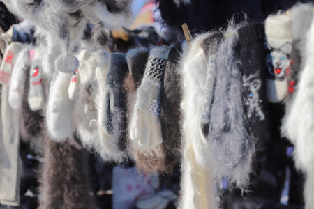 Hand-woven woolen gloves hang on a clothesline on clothespins close-upの写真素材