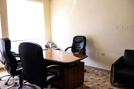 An interior view of modern office with chairs and glass-top table, telephone and other booklets.の写真素材