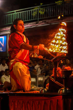 Hindu priest performing  evening rituals during evening for hindu gods and goddess. Hindu priest performing arati by worshipping with lights.のeditorial素材