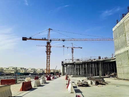 Doha, Qatar- November 8 2018: Construction site of a big shopping mall in Doha, Qatar showing cranes, lifters, concretes, buildings, heavy machineries and steel frameworks.のeditorial素材