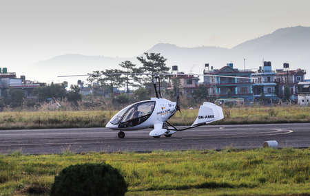 Pokhara, Nepal- December 4 2019: A gyro-copter aircraft ready for take off from a runway with a...