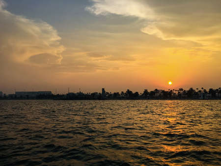 Beautiful sunset view at Doha Corniche, Qatar showing sea, road, sky, clouds and trees.のeditorial素材