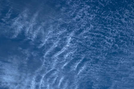 Beautiful blurry pattern of intermittent and scattered clouds on a sunny day with the blue sky as background. Bluish sky color as abstract background or backdrop.の写真素材