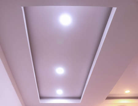 Modern interior design for living room, conference room and hotels. False ceiling co-ply design using gypsum or plaster of paris. Illuminated new home interior with false ceiling lighs.の写真素材