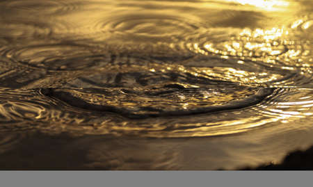 Close-up of water ripples showing the shapes of waves of water. Beautiful abstract background of ripples of water with turbulent flow.の写真素材