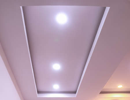 Modern interior design for living room, conference room and hotels. False ceiling co-ply design using gypsum or plaster of paris. Illuminated new home interior with false ceiling lighs.の写真素材