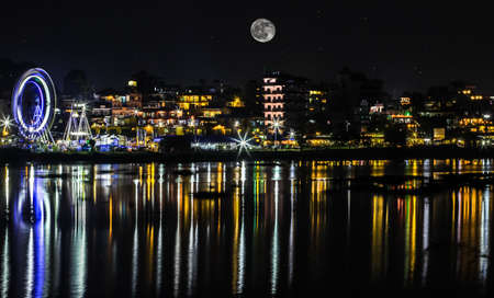 Beautiful evening in Lakeside, Nepal with city lights reflections on fewa lake. Full-moon night in Pokhara, Nepal. Long exposure photograph of city lights reflections on fewa lake of Nepal.の写真素材