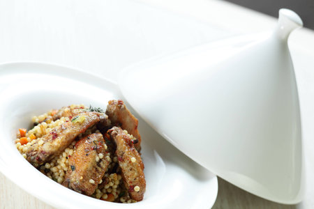 Peaces of meat with millet in the white dishの写真素材
