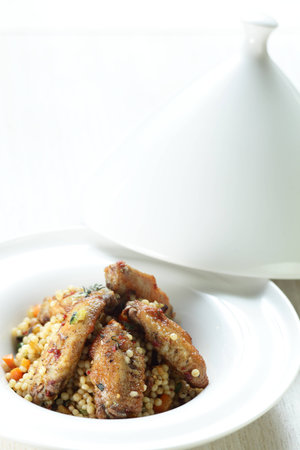 Peaces of meat with millet in the white dishの写真素材