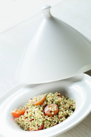 Millet in the white dish on wooden tableの写真素材