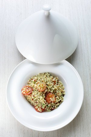 Millet in the white dish on wooden tableの写真素材