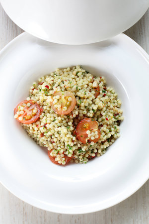 Millet in the white dish on wooden tableの写真素材