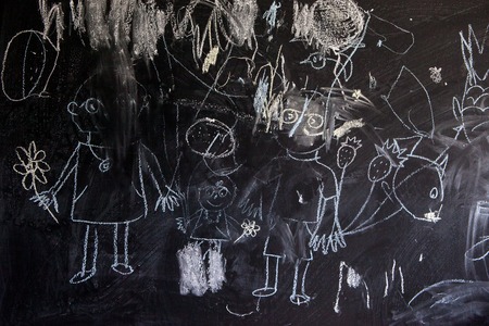Children drawing with chalk on a school blackboard happy family and shaded areasの写真素材
