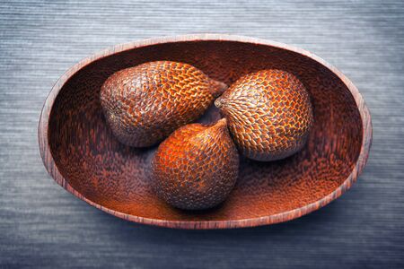 Salak or snake fruit in a wooden textured plate, exotic plantsの写真素材