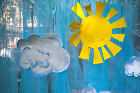The decorations of appliques, paper sun and clouds on a blue backgroundの写真素材
