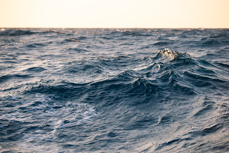 Large sea waves at sunset closeupの写真素材