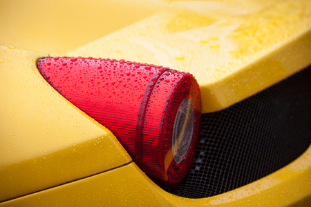 Yellow sport car tail light with rain dropsの写真素材