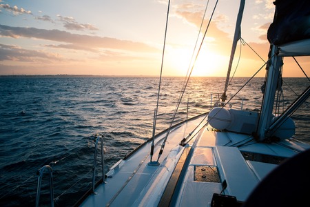 Sailing yacht at sunset in the open seaの写真素材