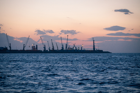 Marine cargo port with cranes at sunsetの写真素材