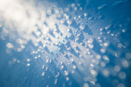 Morning dew on a white surface in the sunの写真素材