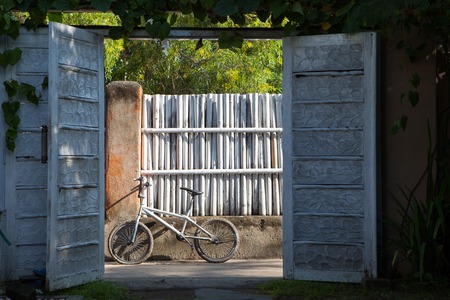 Old white Bicycle in the countryside on the background of the fenceの写真素材