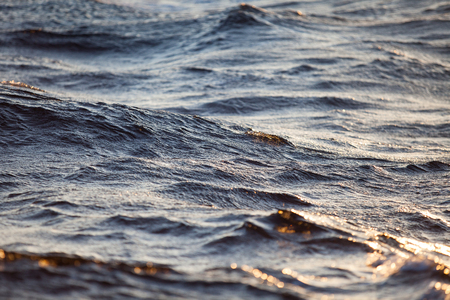 Large sea waves at sunset closeupの写真素材