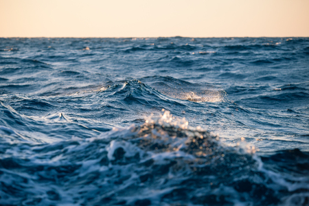 Large sea waves at sunset close up in a strong windの写真素材