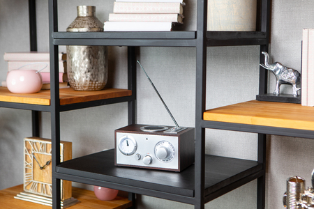Compact radio on bookshelf in vintage living room interiorの写真素材