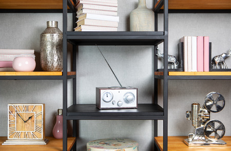 Compact radio on bookshelf in vintage living room interiorの写真素材