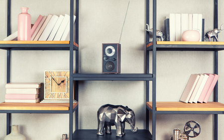 Compact radio on bookshelf in vintage living room interiorの写真素材