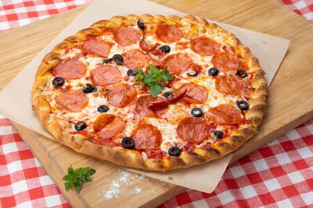 Pepperoni pizza close-up with various ingredients decorated with Basil, an assortment of traditional Italian fast foodの写真素材